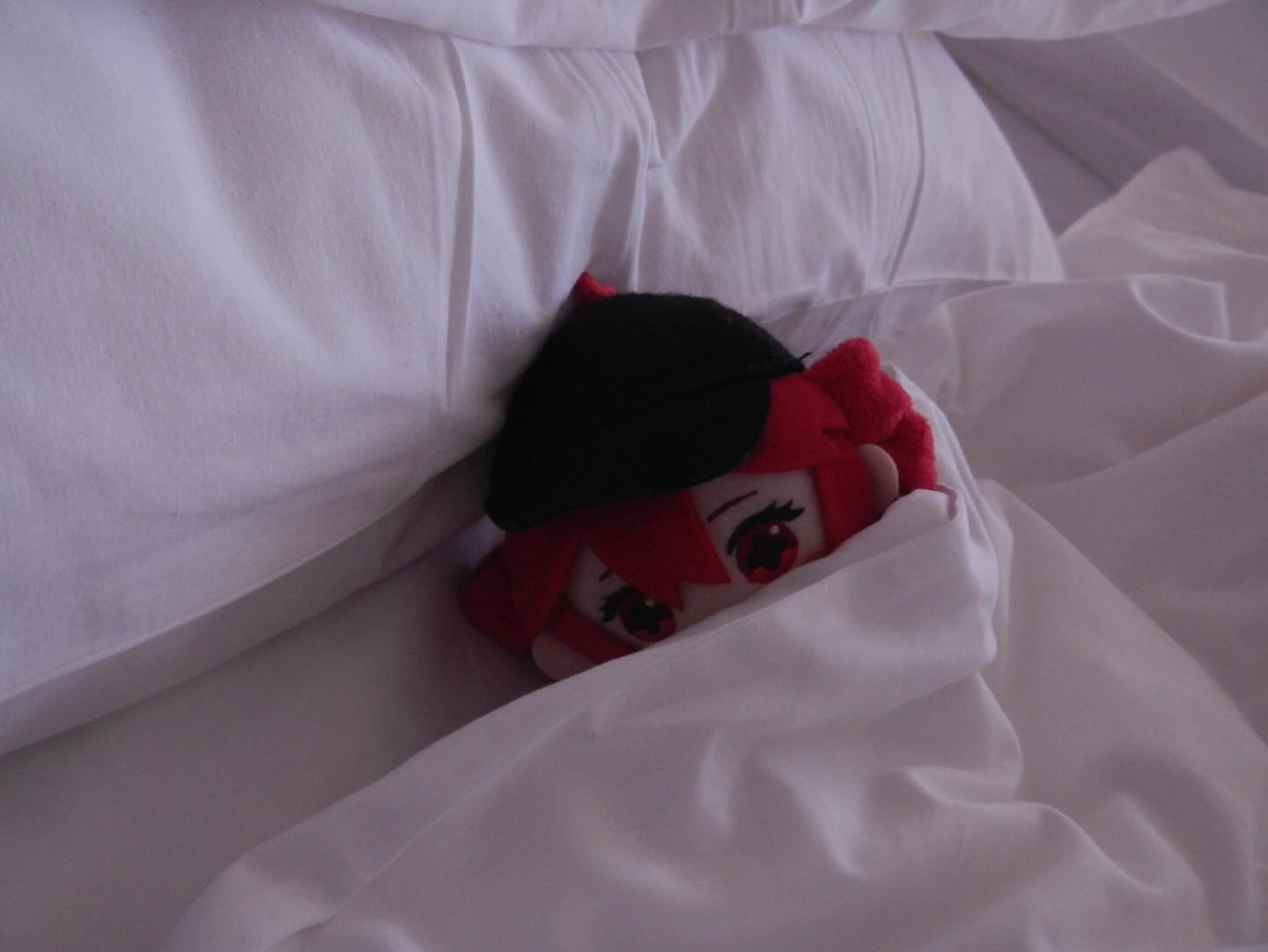 An Override Teto plushie tucked in a white bed with a white blanket and pillow. 

Photo by @_wandering.teto_ on Instagram.