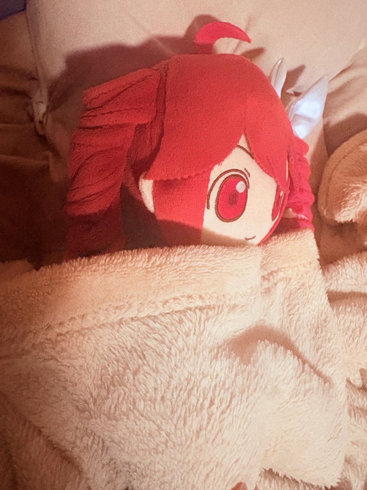 A SynthV Teto plushie sleeping on her side covered in a light pink blanket.

Photo by @pokumo_de_pon on Twitter.