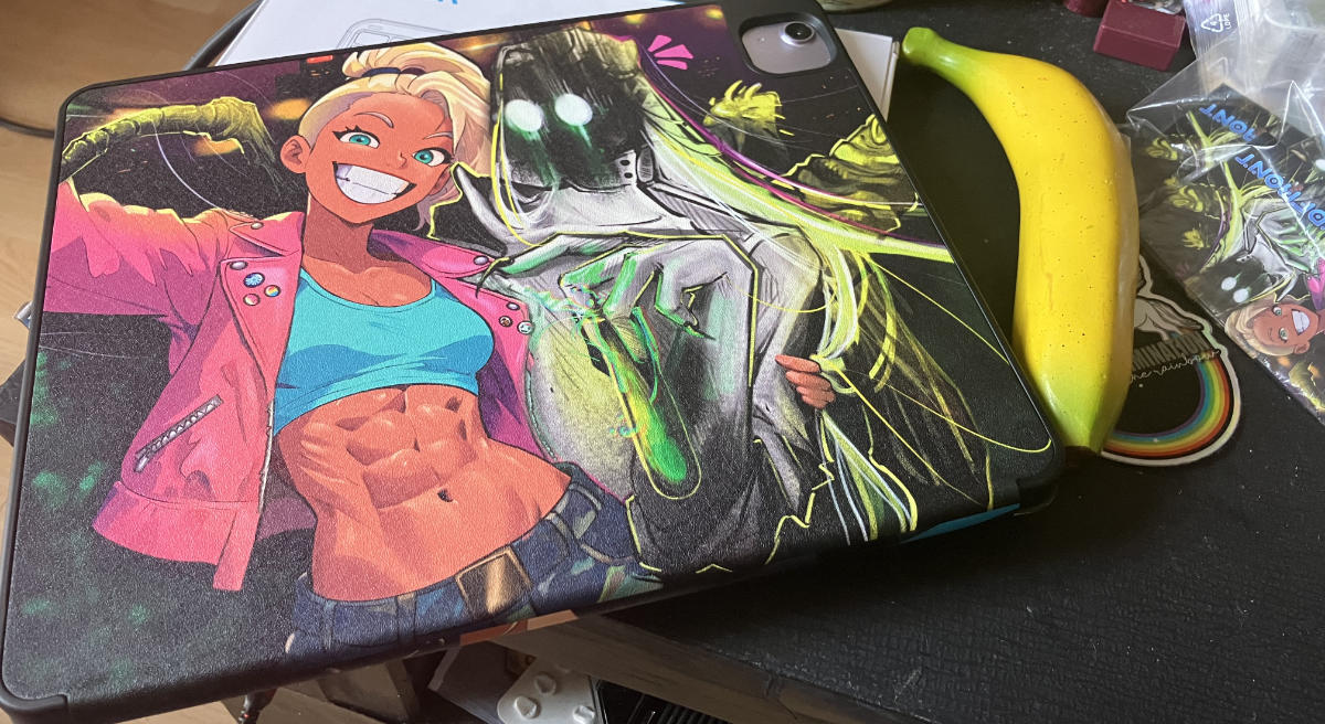 Rear side of the cover with the selfie collab illustration (featuring Kait and Petrichor) by labdweller and me. Banana for scale next to it.
